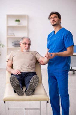 Yaşlı erkek hasta, genç doktor.