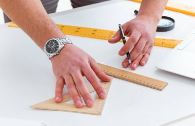 Erkek mühendis çizimler ve planlar üzerinde çalışıyor.