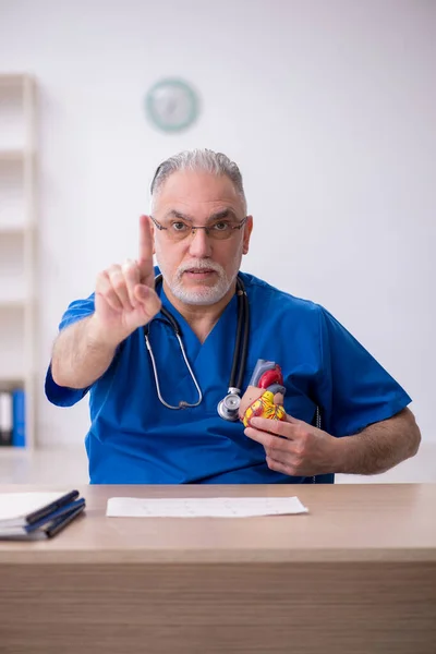 Médico cardiologista idoso trabalhando na clínica — Fotografia de Stock