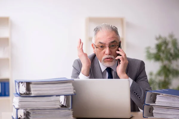 Alte männliche Angestellte unzufrieden mit exzessiver Arbeit im Büro — Stockfoto