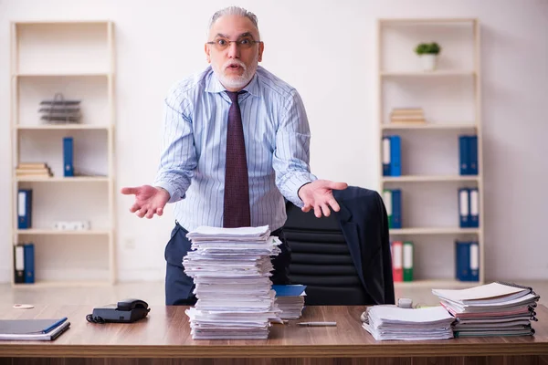 Öreg üzletember alkalmazott elégedetlen a túlzott munka az irodában — Stock Fotó