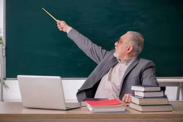 Oude mannelijke leraar voor schoolbord — Stockfoto