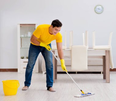 Evi temizleyen adam karısına yardım ediyor.