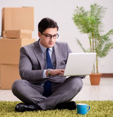 Ofiste halının üzerinde oturan bir iş adamı.