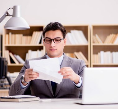 İşadamı mektup zarfını ofisinde alıyor.