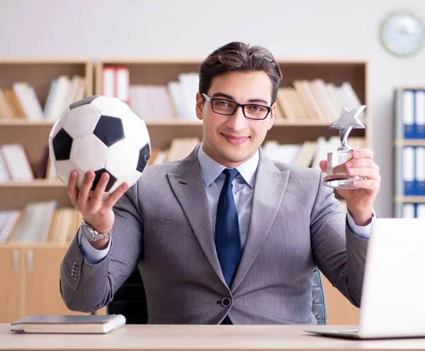 Empresário com bola de futebol no escritório — Fotografia de Stock