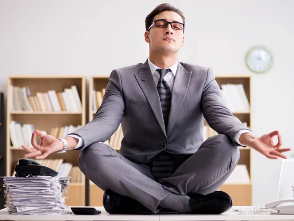 Young businessman meditating in the office — Stock Photo, Image