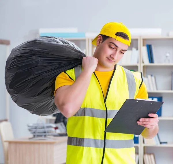 Homem limpando o escritório e segurando saco de lixo — Fotografia de Stock