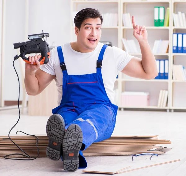 Trabajador joven que trabaja en baldosas laminadas piso — Foto de Stock