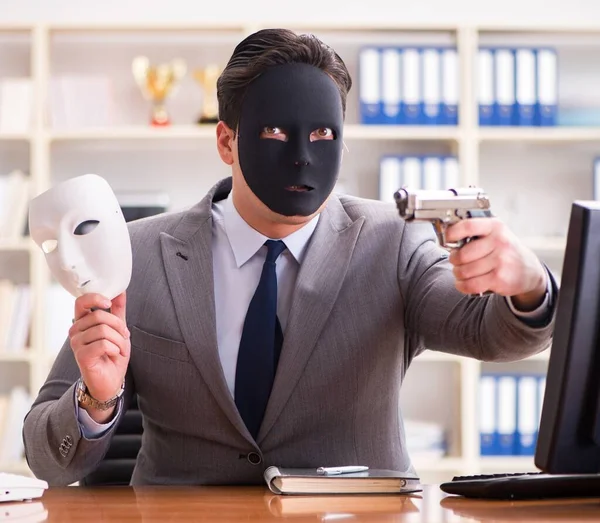 Businessman with mask in office hypocrisy concept