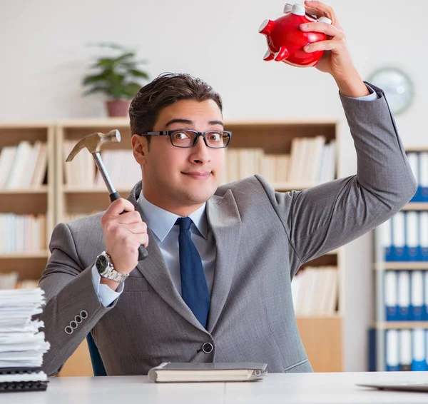 Zakenman op zoek naar zijn spaargeld bij piggy bank — Stockfoto