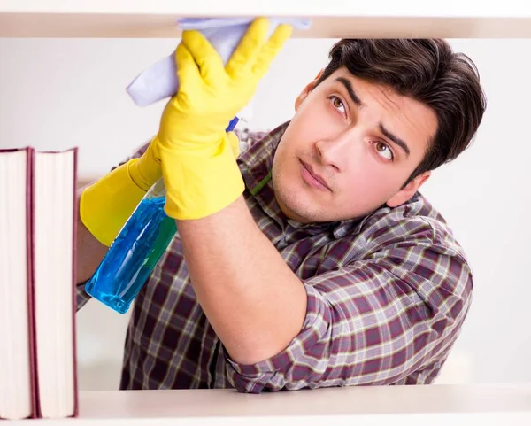 Kitaplıktaki tozları temizleyen adam