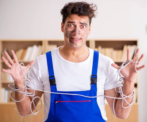 Смешной человек, делающий ремонт электропроводки дома — стоковое фото
