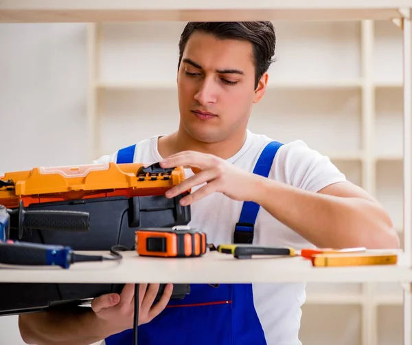 İşçi adam montaj kitaplığını tamir ediyor