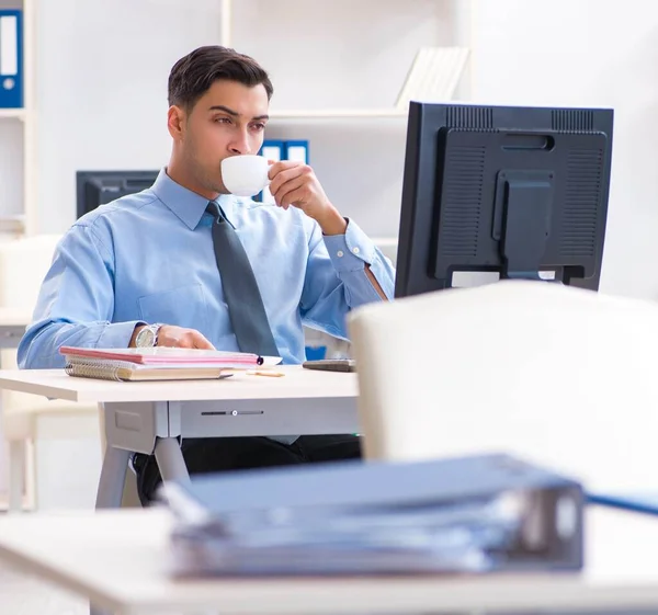 Bonito empresário empregado sentado em sua mesa no escritório — Fotografia de Stock