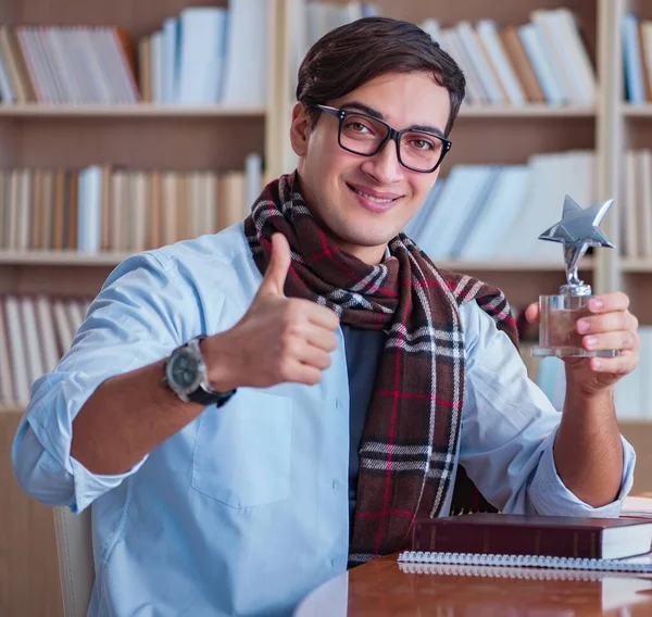 Young book writer writing in library