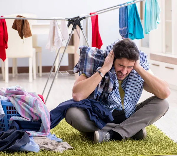 Jóképű férj, aki otthon mossa a ruháit. — Stock Fotó