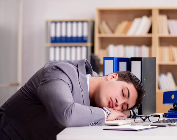 Un hombre de negocios soñoliento trabajando en la oficina — Foto de Stock