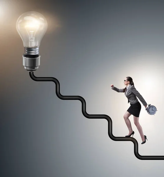 Businesswoman climbing career ladder towards light bulb — Stock Photo, Image