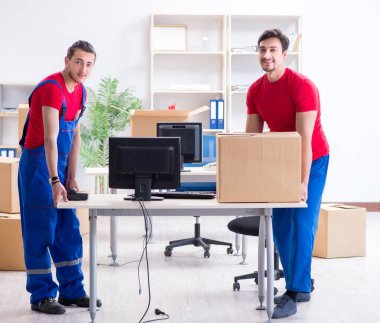 İki müteahhit personel kişisel eşyalarını taşıyor.