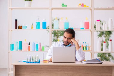 Genç erkek kimyager laboratuarda sabun test ediyor.