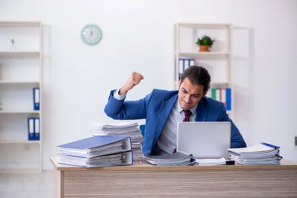 Joven empleado masculino descontento con el trabajo excesivo en la oficina —  Fotos de Stock