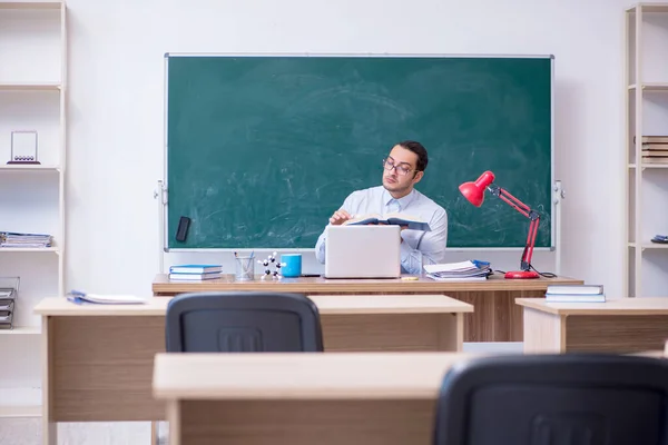 Junger männlicher Lehrer vor grünem Brett — Stockfoto