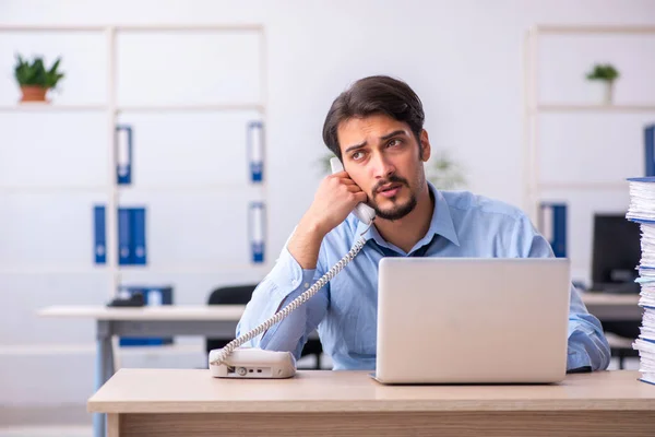 Junge männliche Mitarbeiter und zu viel Arbeit im Büro — Stockfoto