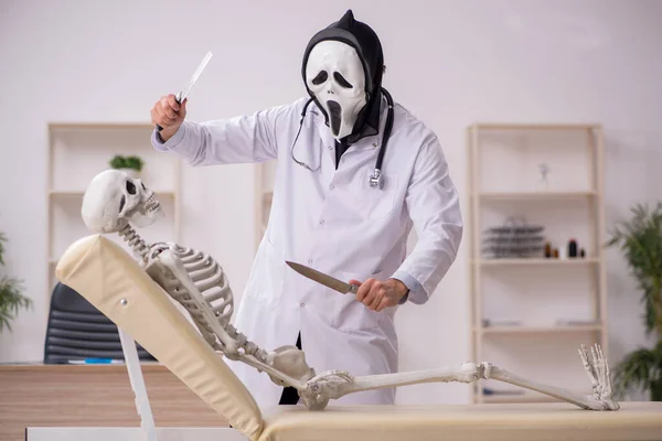 Devil medico esaminando paziente scheletro — Foto Stock