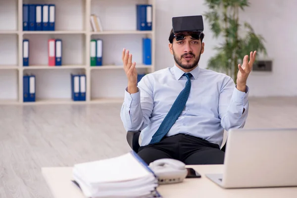 Junge männliche Angestellte mit virtueller Brille am Arbeitsplatz — Stockfoto