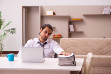 Genç erkek çalışan salgın sırasında evden çalışıyor.