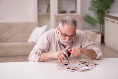 Yaşlı hasta adam evde acı çekiyor.