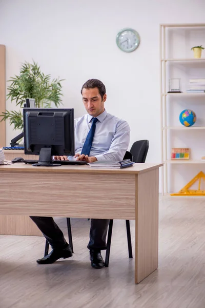 Jeune employé masculin assis dans le bureau — Photo