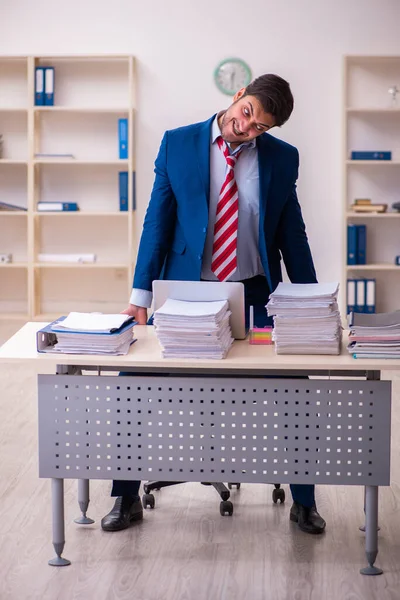 Молодий працівник бізнесмена незадоволений надмірною роботою в офісі — стокове фото