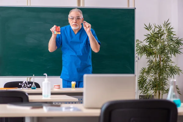 Velho médico dentista na sala de aula — Fotografia de Stock