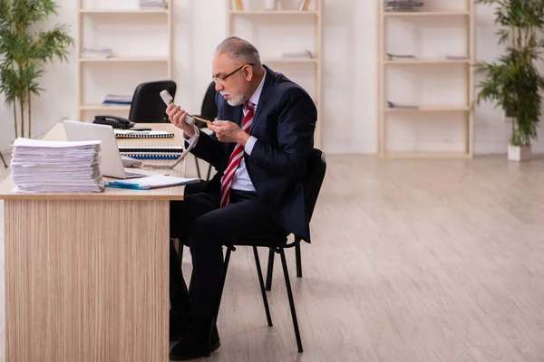Old businessman employee sitting in the office — Stock Photo, Image
