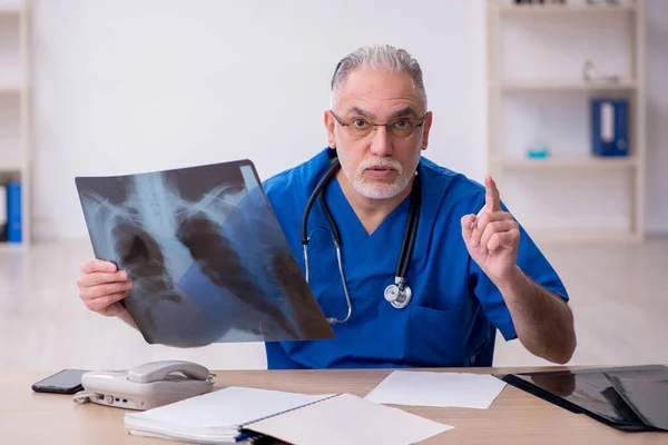 Gammal manlig röntgenläkare som arbetar på kliniken — Stockfoto