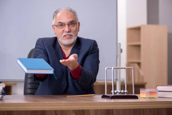 Antigo professor físico sentado na sala de aula — Fotografia de Stock