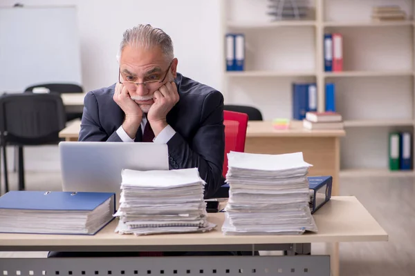 Åldrad manlig anställd och för mycket arbete på arbetsplatsen — Stockfoto