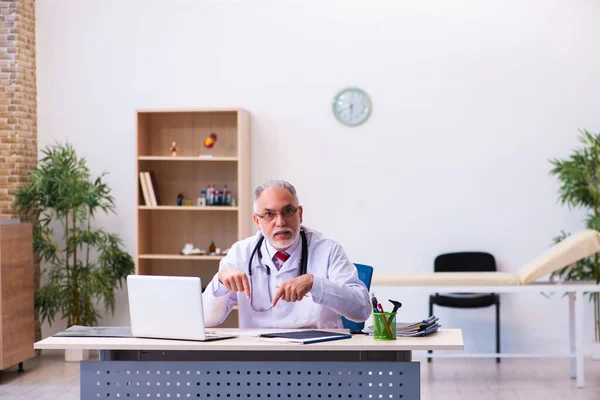 Vecchio medico di sesso maschile che lavora in clinica — Foto Stock