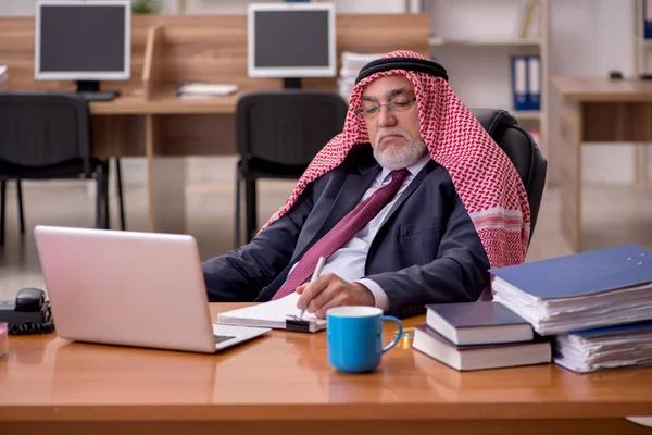 Elöregedett arab üzletember alkalmazott, aki a munkahelyén ül — Stock Fotó