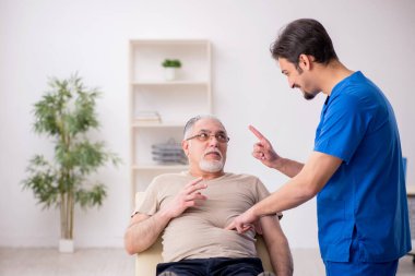 Yaşlı erkek hasta, genç doktor.