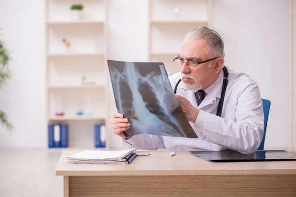 Old male doctor radiologist working in the clinic during pandemi — Stock Photo, Image