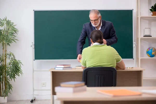 Věk učitel a mladý muž student ve třídě — Stock fotografie