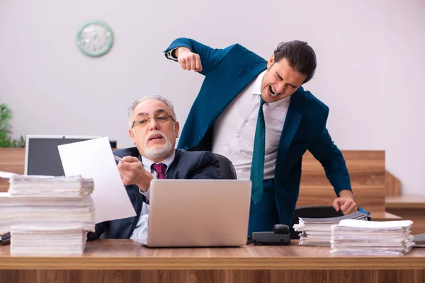 Alte männliche Arbeitgeber und junge männliche Assistenten im Mobbing-Konzept — Stockfoto