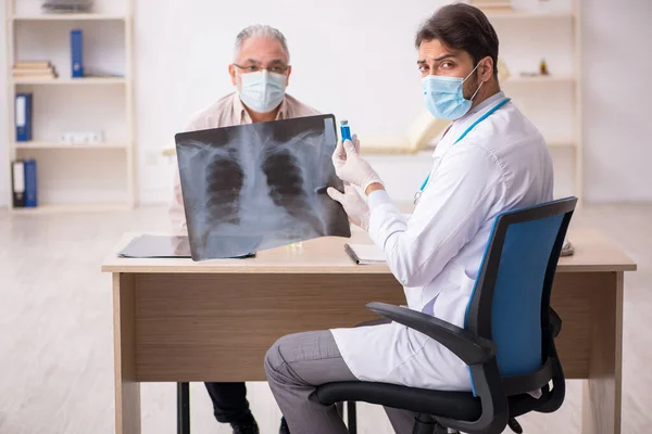 Idős férfi beteg látogató fiatal férfi orvos radiológus a p — Stock Fotó
