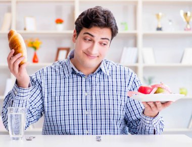 Diyet dolandırıcılığında sağlıklı yemek ve ekmek arasında ikilem yaşayan bir adam.