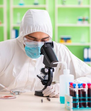 Laboratuvarda yeni bir deney üzerinde çalışan kimyager.