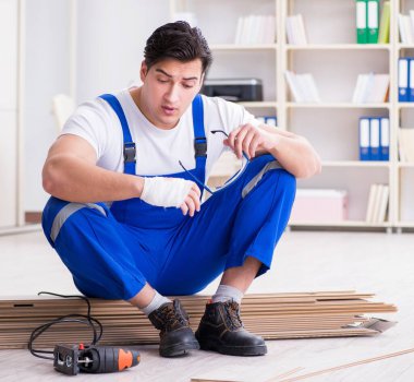 Zemin kaplamalarında çalışan genç bir işçi.