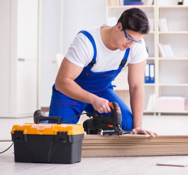 Zemin kaplamalarında çalışan genç bir işçi.